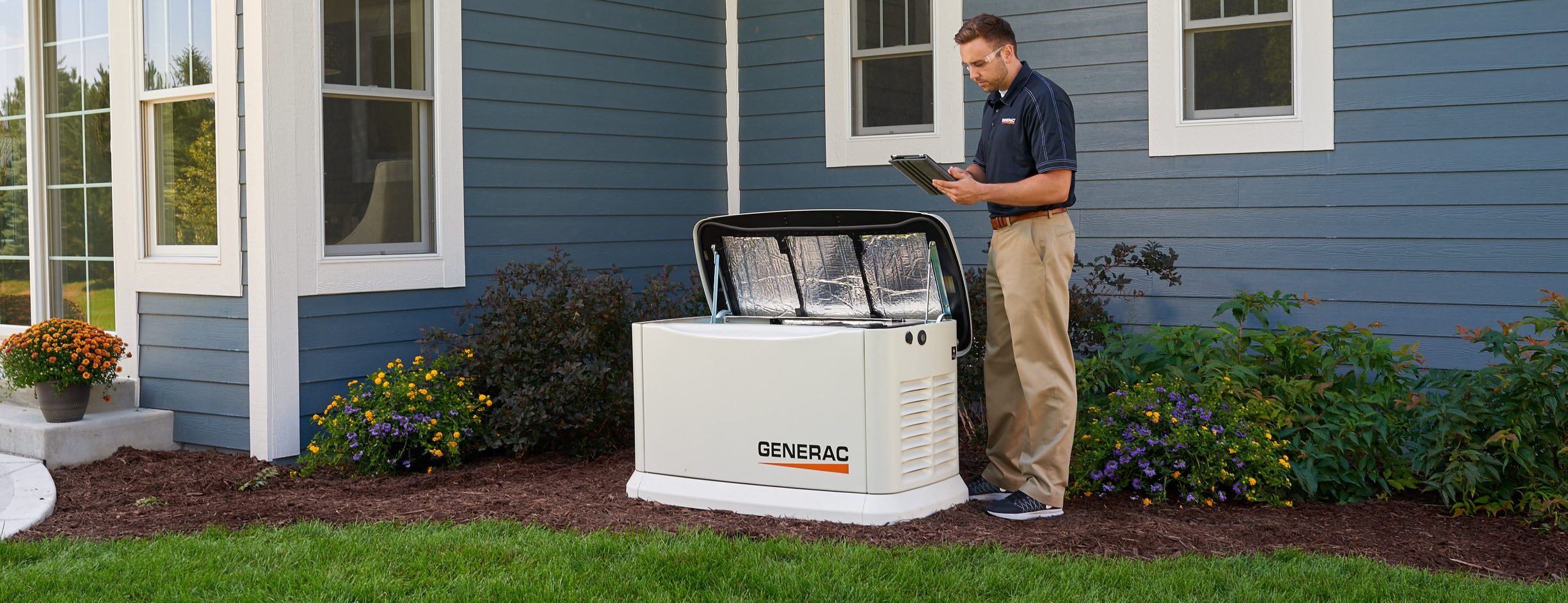 A technician inspecting an open Generac home standby generator during a service visit